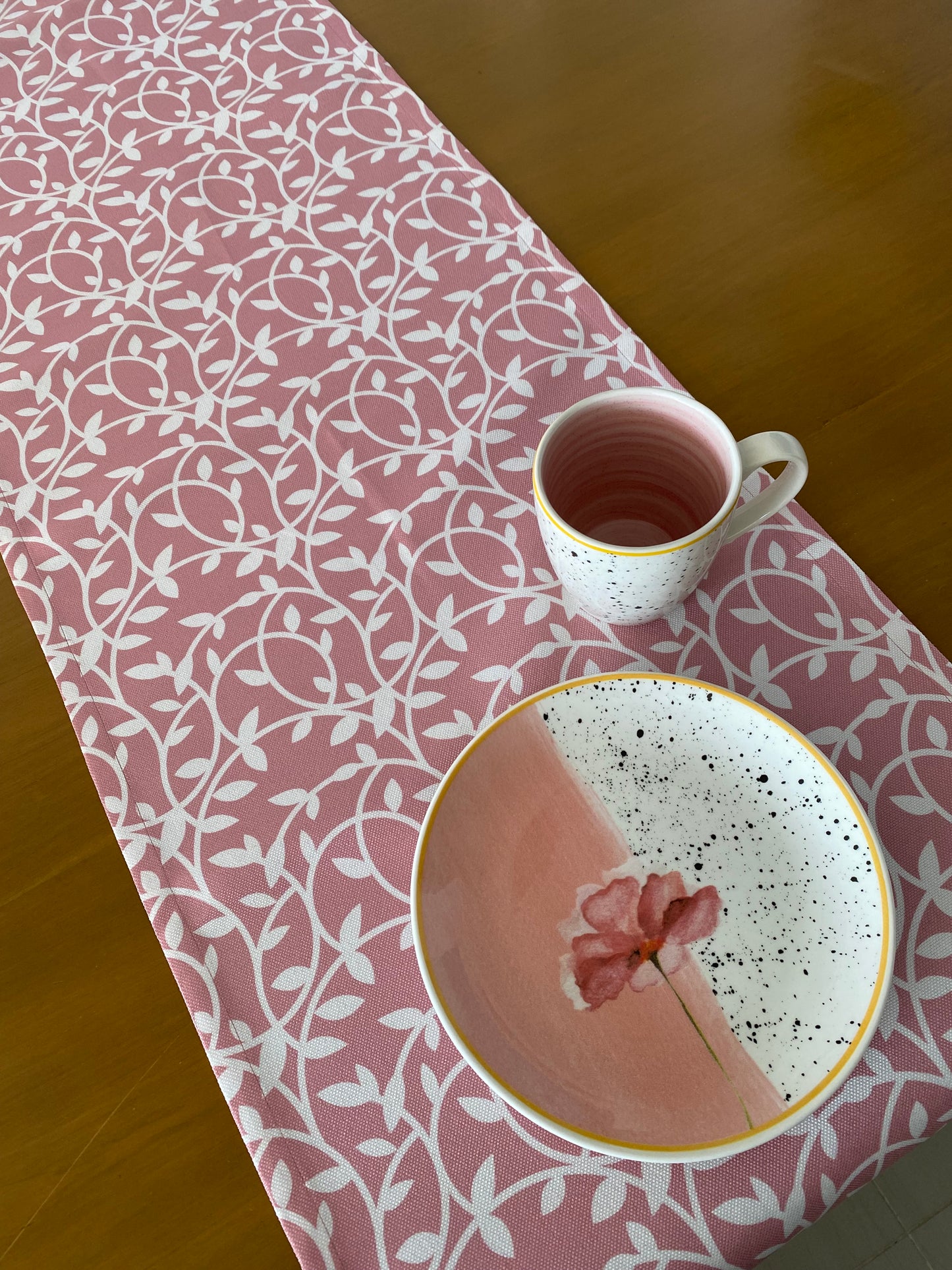 Camino de mesa rosado con hojas blancas